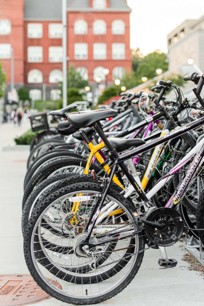 bikes lined up on a bike rack by the university of wisconsin madison in the summer